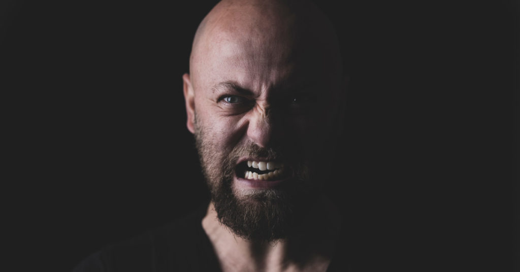 A scowling man displays chronic anger.
