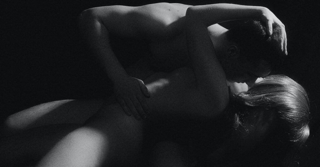 A black and white image of a heterosexual couple embracing.