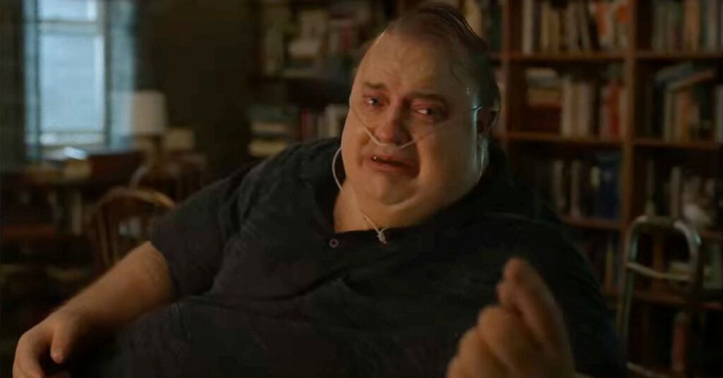 A still from The Whale movie shows actor Brendan Fraser weeping, with a nasal tube.